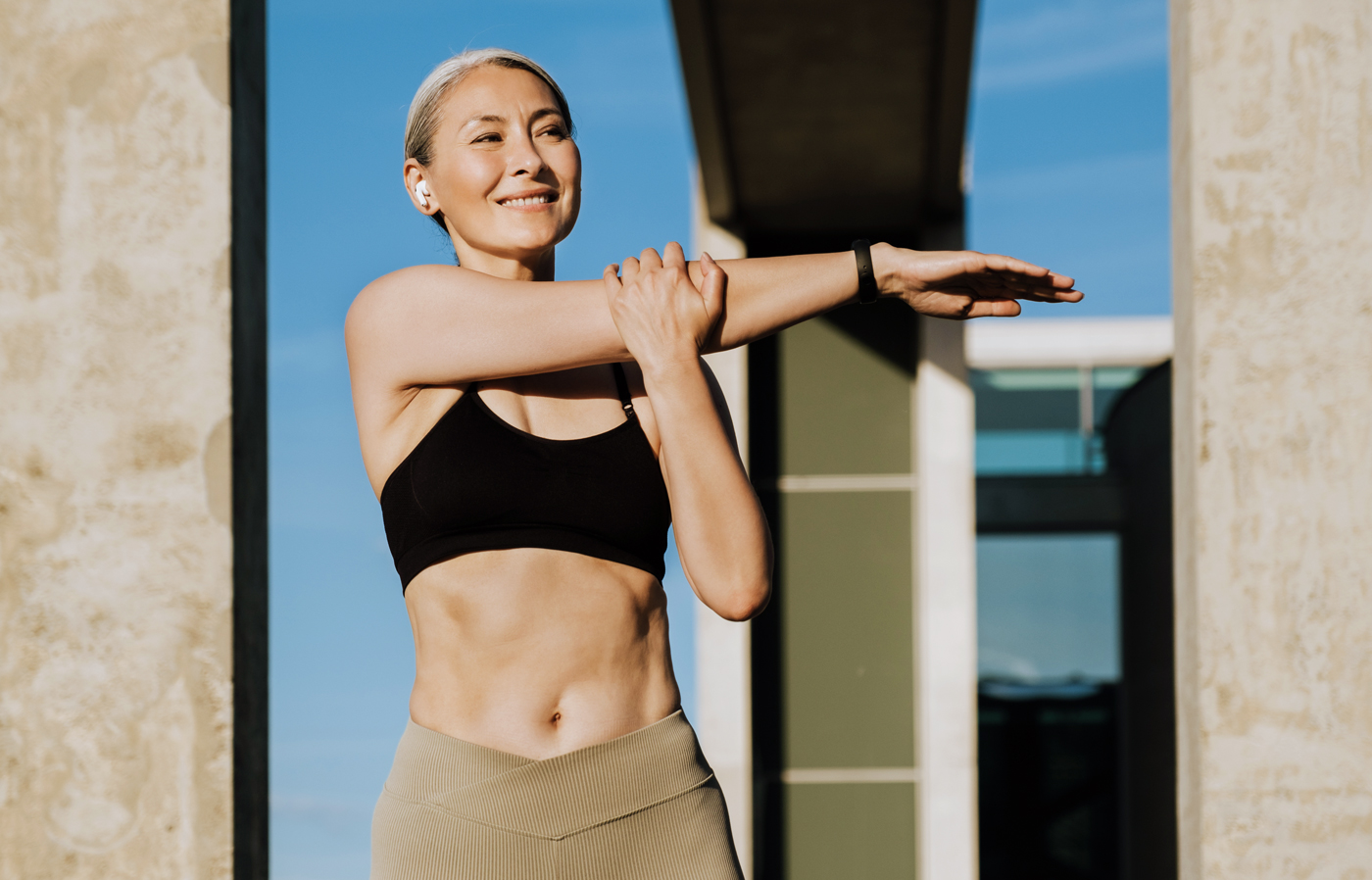 A woman in menopause stretches outside before going for a run.