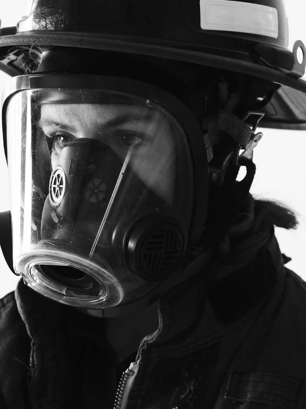 A close-up of Hélina Bear in her firefighter helmet and mask.